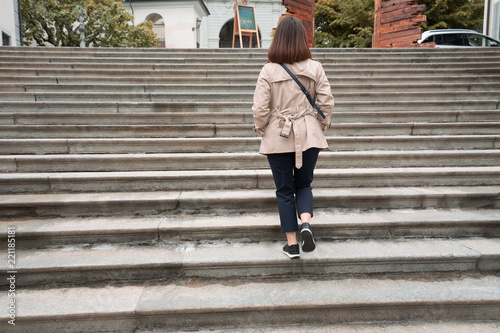 Working woman is walking up the stairs.
