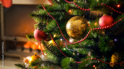 Closeup image of golden shiny bauble on Christmas tree at living room