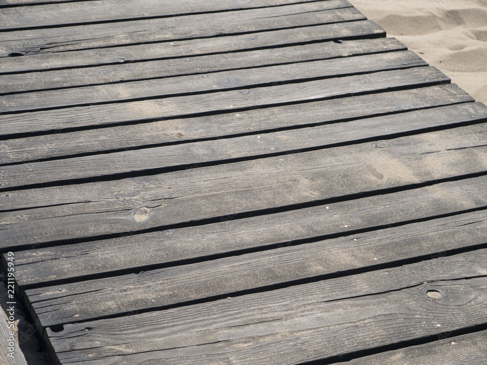 Detail top of view of a wooden wooden beach path with some sand Detail top of view of a wooden wooden beach path with some sand