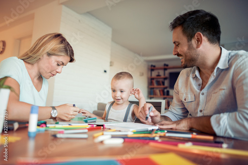 Young parents with young child draw