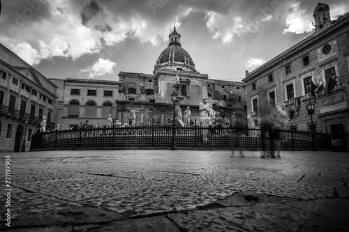 Black and white long exposure picture of Fontana Pretoria in Palermo (Sicily, Italy) with tourists