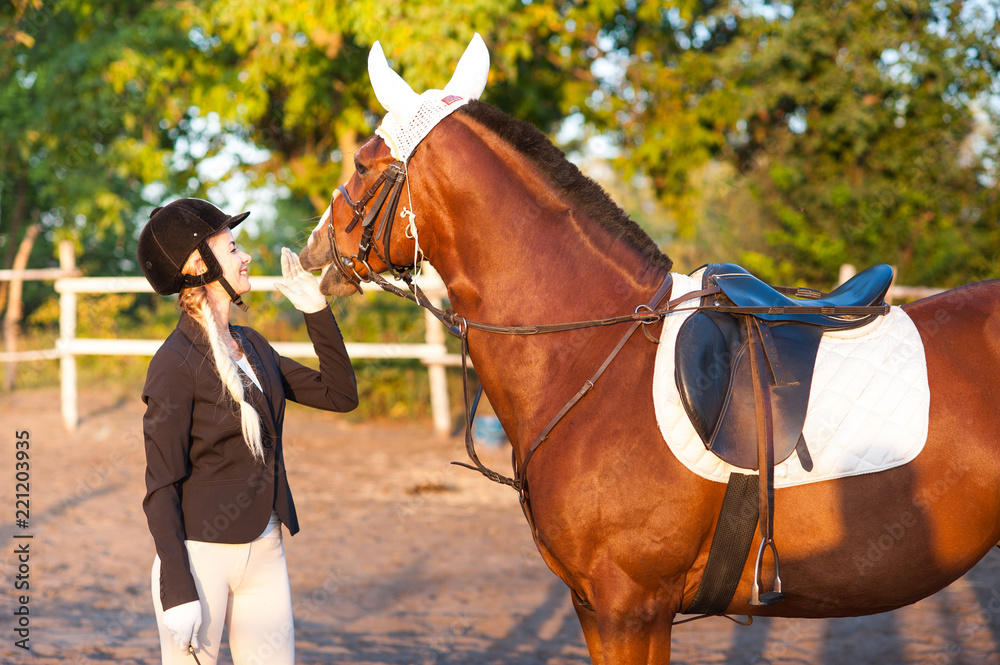 Obraz premium A beautiful girl rider walks with a horse. Horse theme