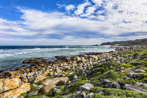 Picturesque view of the rocky shoreline of Atlantic Ocean and Platboom Beach. Platboom Bay is a beautiful beach along coastline nestled in Cape of Good Hope Nature reserve, Cape Town, South Africa. photo