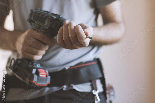 Professional handyman changing a drill bit photo