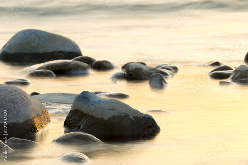 the stream of water during sunset and the beautiful stones on it