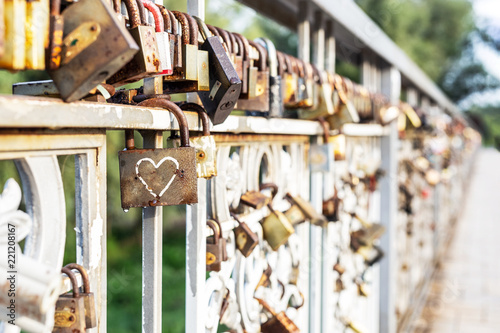 Red heart padlock locked on fence. Lock in shape of heart as symbol of eternal love