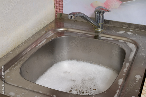 the drain hole was blocked. The sink is filled with water and foam