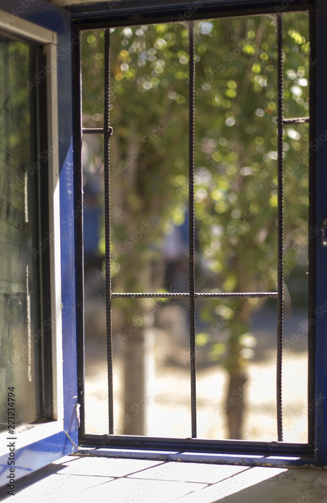 Naklejka premium open window with grilles and hitting the sun beam