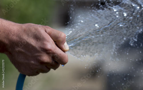 Man's hand with watering from the hose
