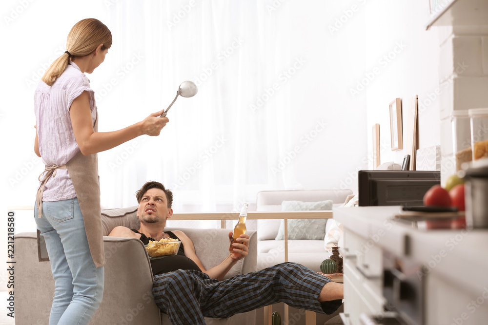 Lazy husband quarrelling with hardworking wife at home