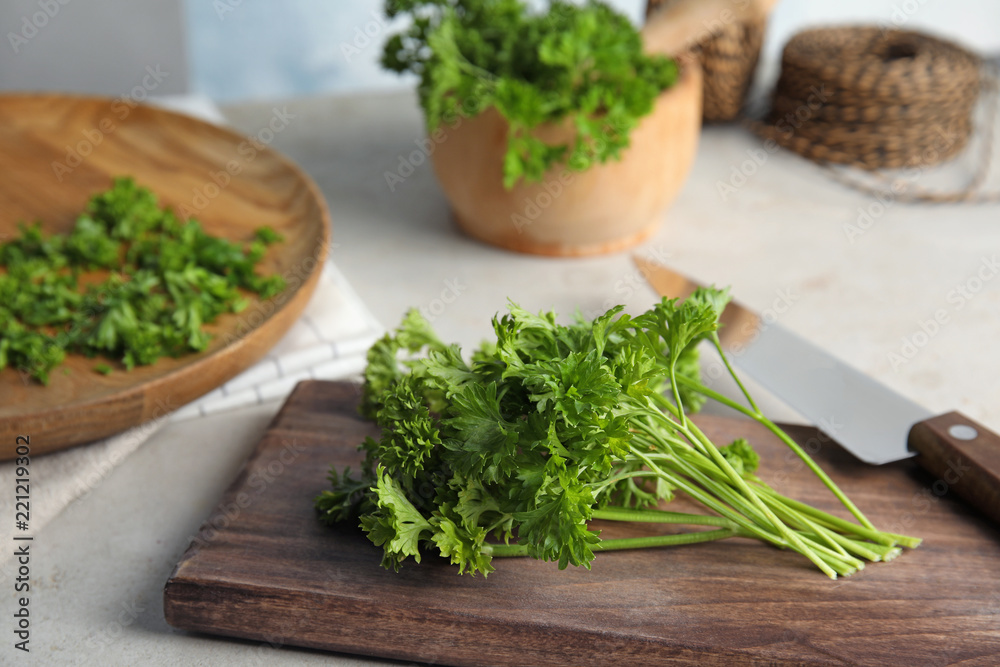 Wooden board with fresh green parsley on table Wooden board with fresh green parsley on table
