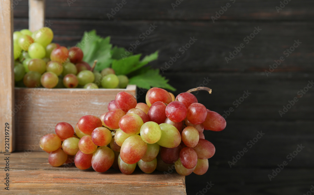 Fresh ripe juicy grapes on table against blurred background with space for text