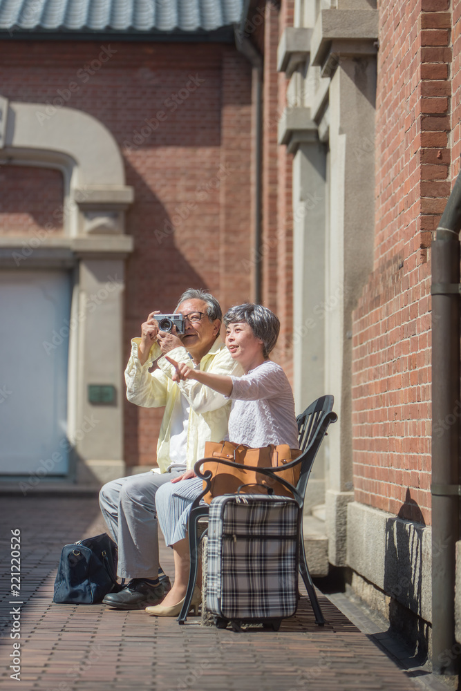 Fototapeta premium 旅先でカメラを構えるシニア夫婦