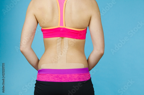 Woman with medical kinesio taping on back