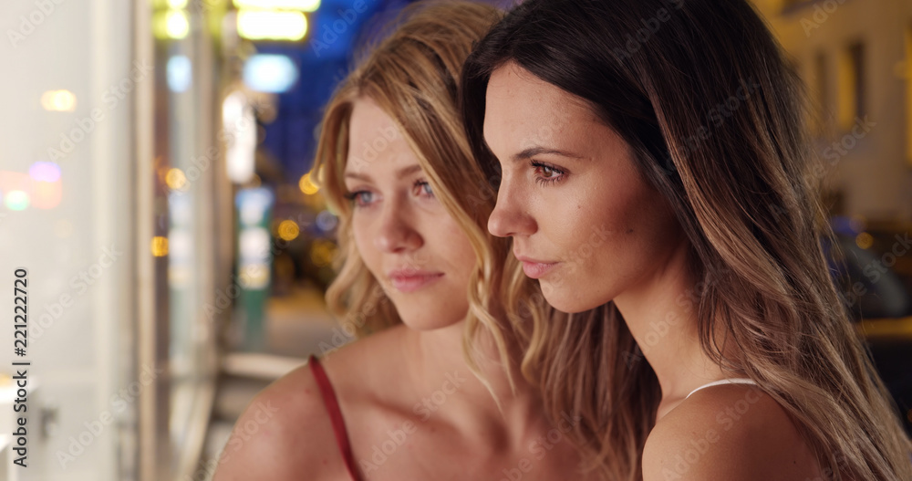 Couple of stunning Caucasian females staring at shop window in the city Couple of stunning Caucasian females staring at shop window in the city