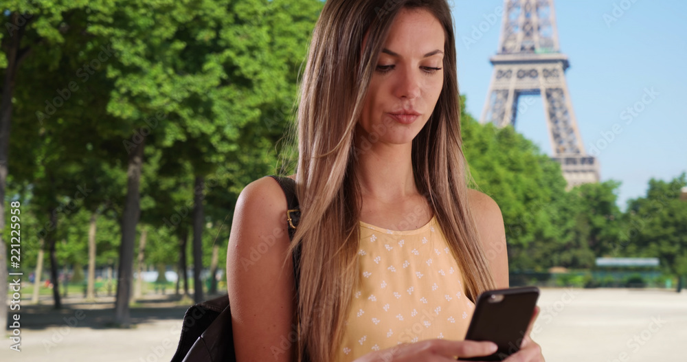 White woman in her 20s taking snap of herself with phone by Eiffel Tower White woman in her 20s taking snap of herself with phone by Eiffel Tower