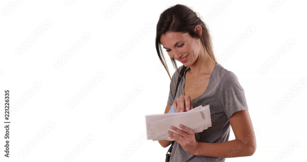 Young Caucasian woman looking through mail she received on white copy space Young Caucasian woman looking through mail she received on white copy space