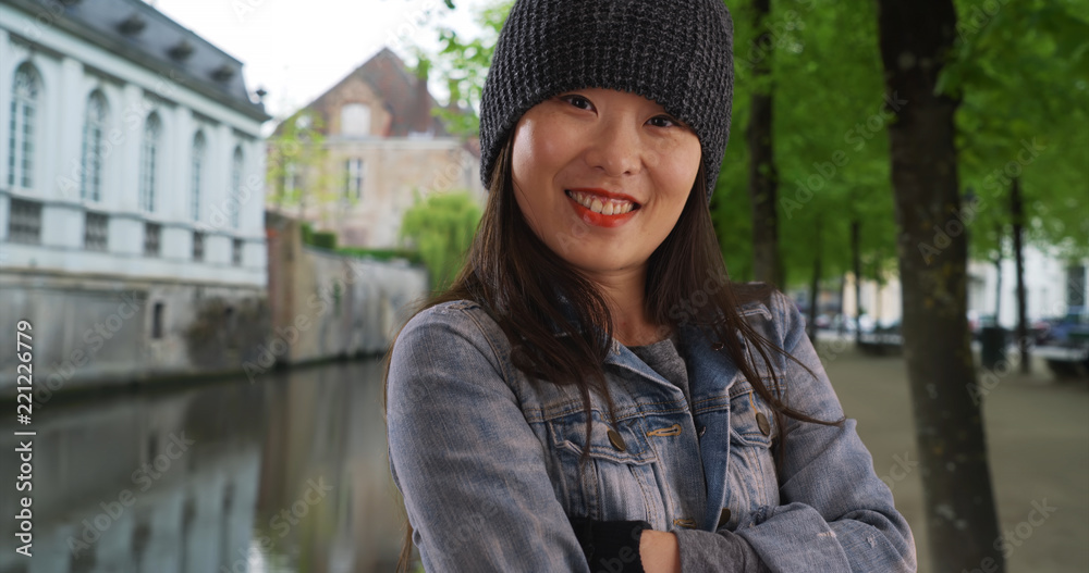 Cold millennial female wearing beanie and mittens in Bruges Belgium