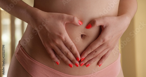 Wallpaper Mural Close shot of young woman covering belly with hands indoors private studio Torontodigital.ca