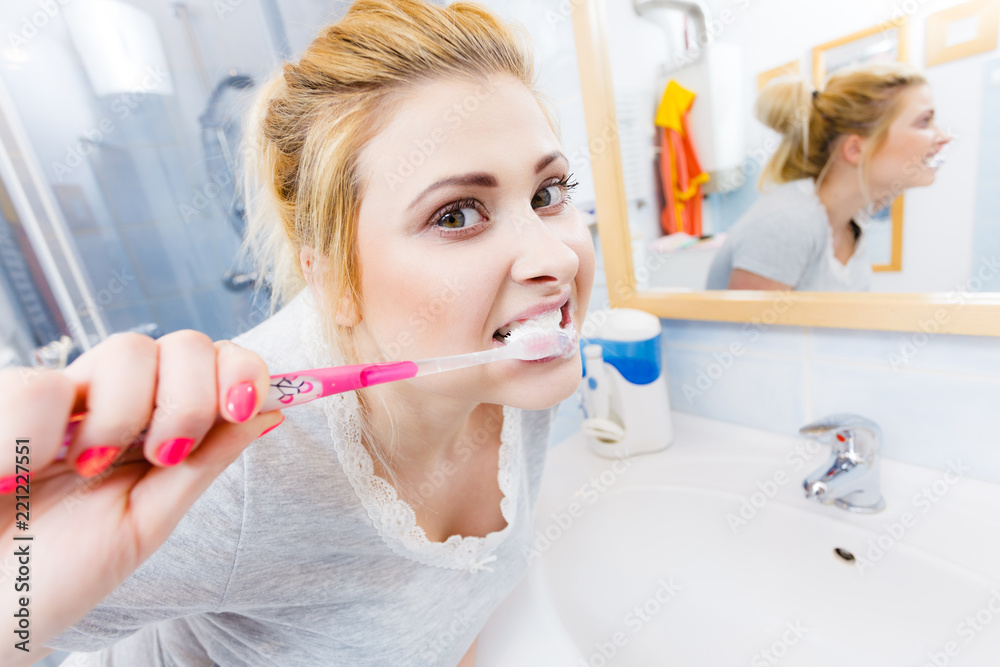 Woman brushing cleaning teeth in bathroom Woman brushing cleaning teeth in bathroom