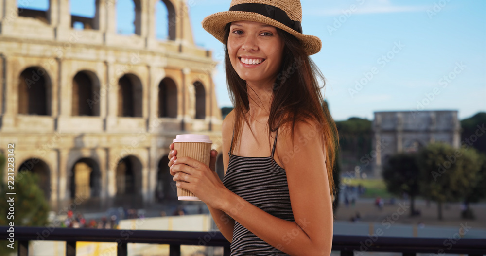 Beautiful young tourist woman with coffee standing near the Roman Coliseum