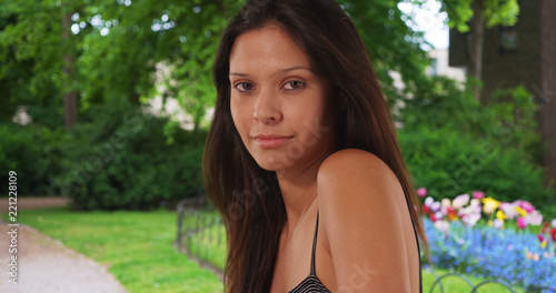 Closeup of beautiful Caucasian girl near flower bed looking over shoulder