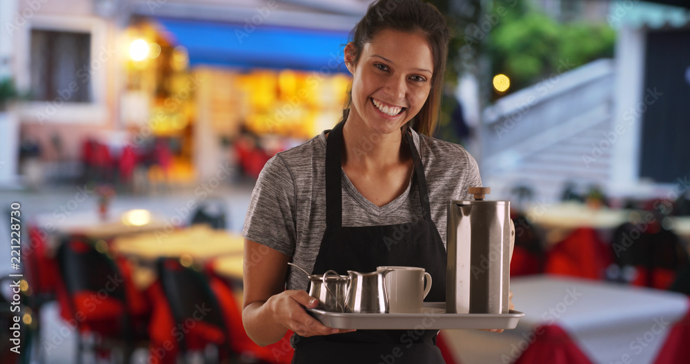 Pretty waitress carrying tray to serve drinks at coffee shop or