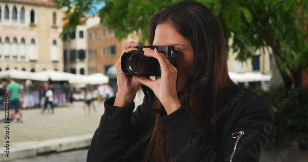 Close up of millennial woman taking photograph of Venice street on vacation