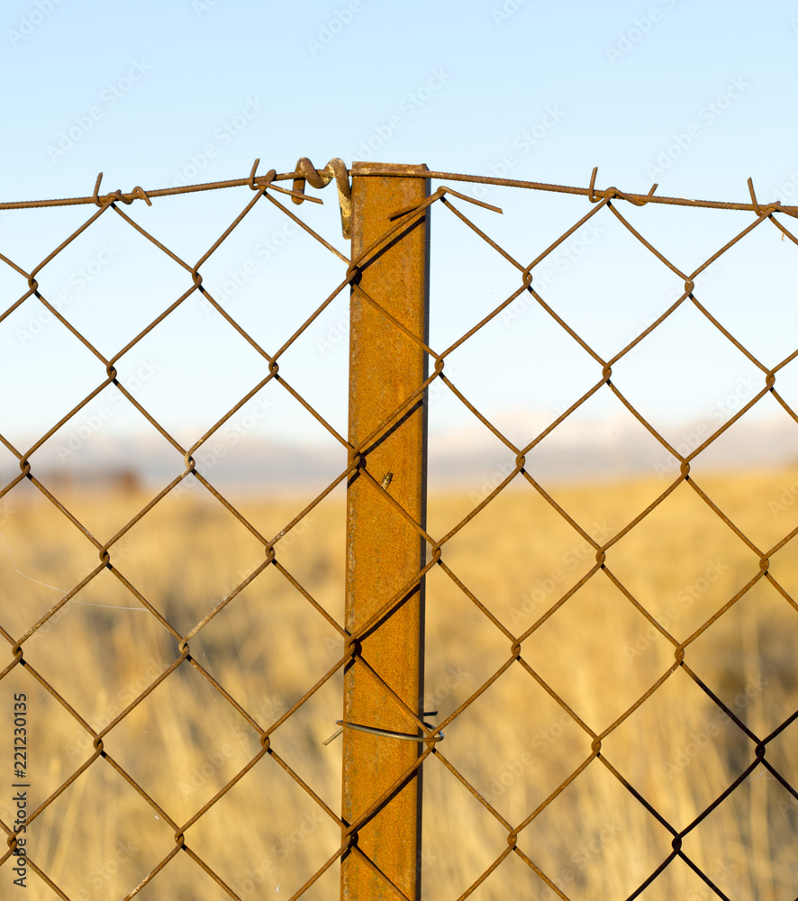 metal fence in the field at sunset metal fence in the field at sunset