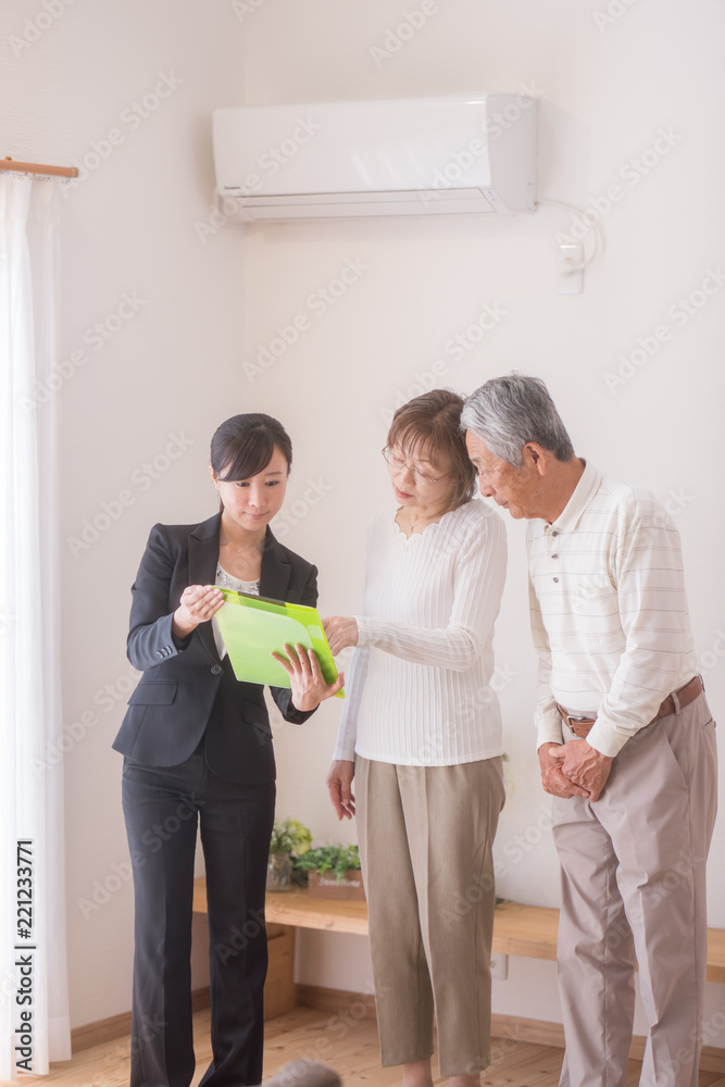 Fototapeta premium 住宅を内見するシニア夫婦と不動産会社のビジネスウーマン
