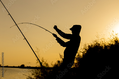 man is fishing at sunset © donikz