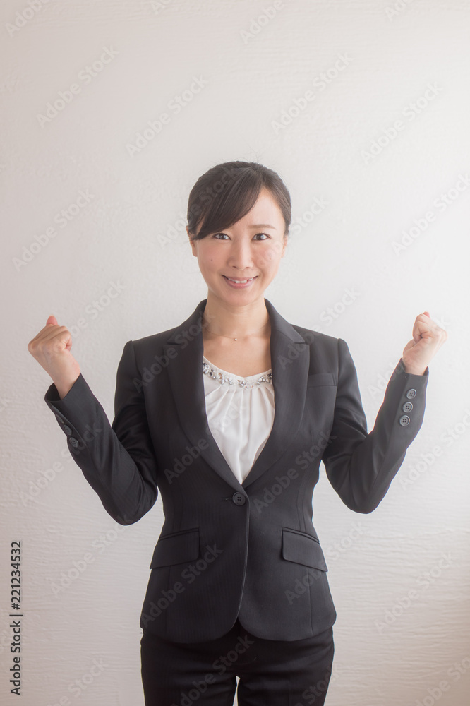 両手でガッツポーズをするスーツ姿の女性 両手でガッツポーズをするスーツ姿の女性
