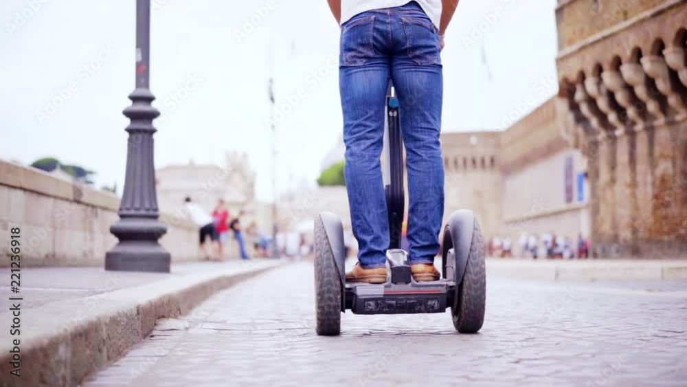 Riding segway in the street of city. Driving a personal transporter while visiting city. Slow motion 100fps