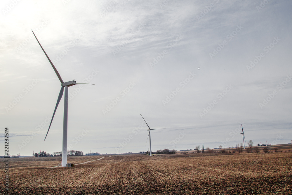 Wind turbines on farmland with overcast sky Wind turbines on farmland with overcast sky