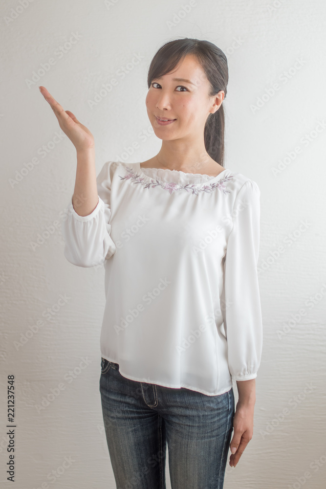 指し示すポーズをする若い女性