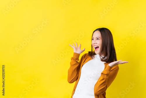 Fotografie Asian girl is surprised she is excited.Yellow background studio