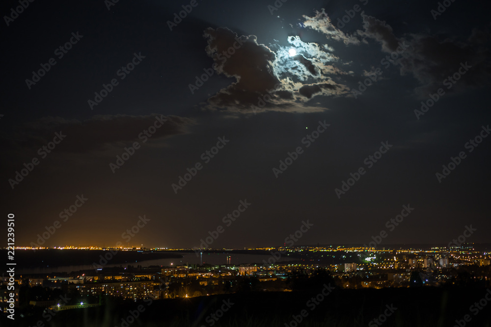 Beautiful moon in the clouds over the night city