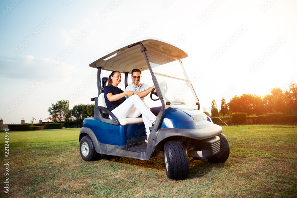 Couple in driving buggy on golf course