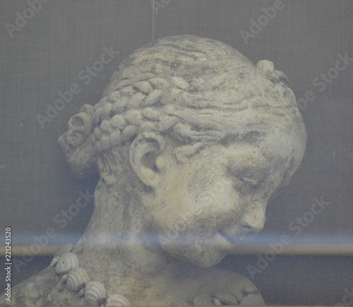 Head of girl sculpture behind a window