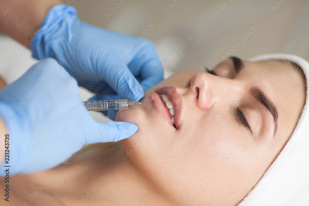 The cosmetologist makes injections of botulinum toxin in the lips of the patient. Cosmetology skin care. The cosmetologist makes injections of botulinum toxin in the lips of the patient. Cosmetology skin care.