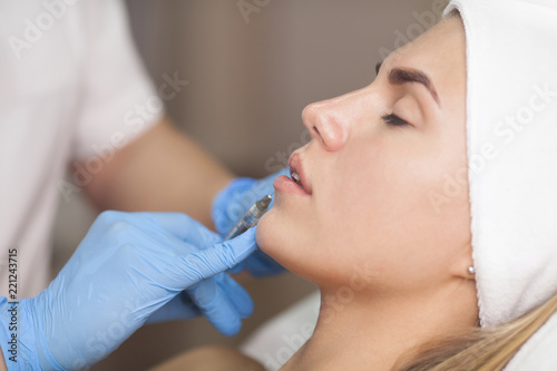 The cosmetologist makes injections of botulinum toxin in the lips of the patient. Cosmetology skin care.