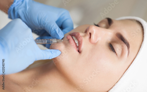 The cosmetologist makes injections of botulinum toxin in the lips of the patient. Cosmetology skin care.