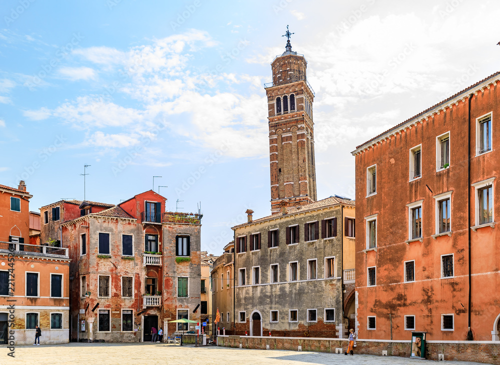 Old square with a leaning bell tower of the Chiesa di Santo Stefano church in the background in Venice Italy