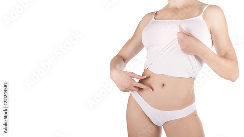 Slim tanned woman's body over gray background.