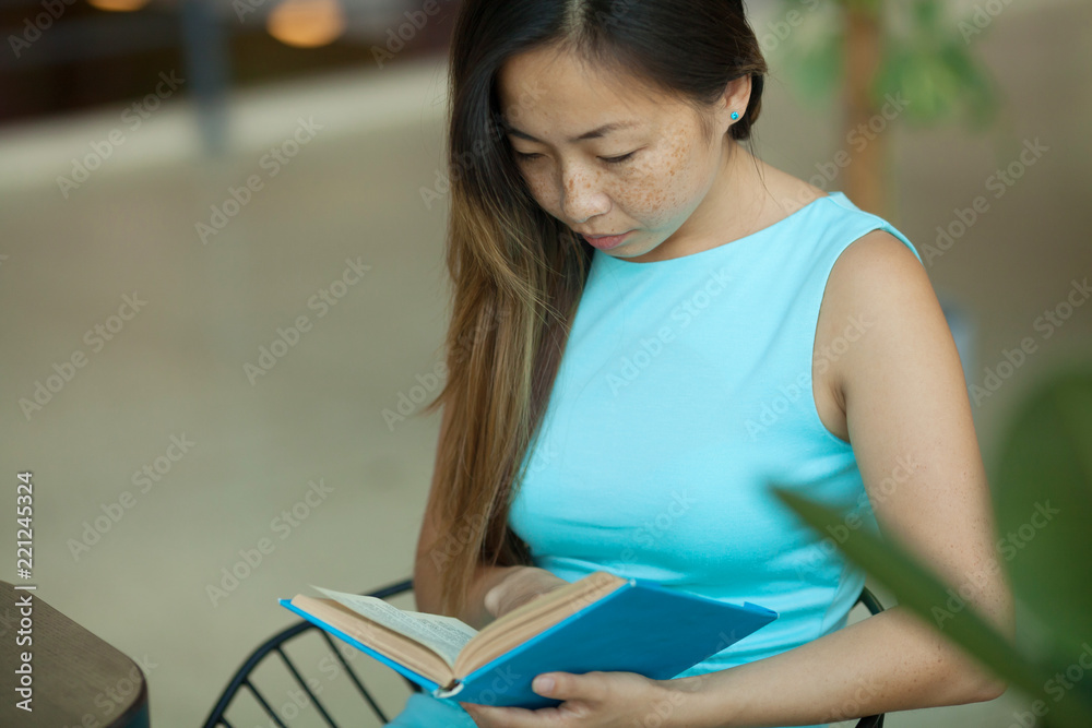 beautiful young asian woman reading a book in cafe beautiful young asian woman reading a book in cafe