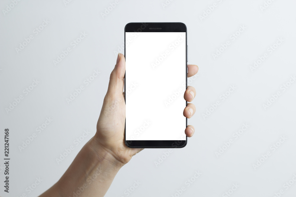 Close-up in the hand of a smartphone with a white screen on a white background. Close-up in the hand of a smartphone with a white screen on a white background.