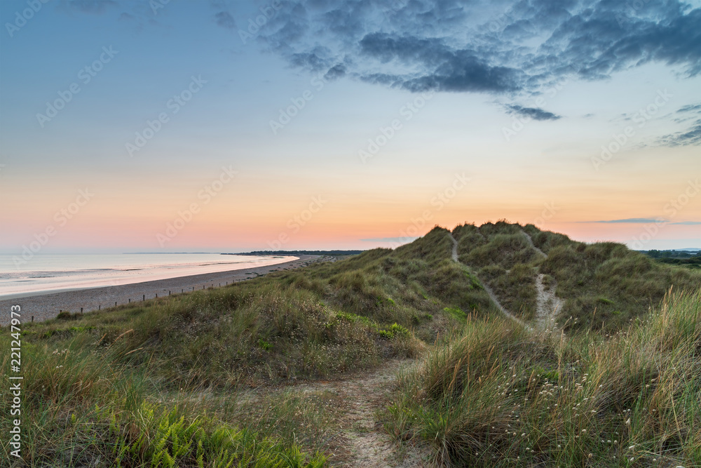 Beautiful vibrant Summer sunset beach landscape with stunning sky and colors