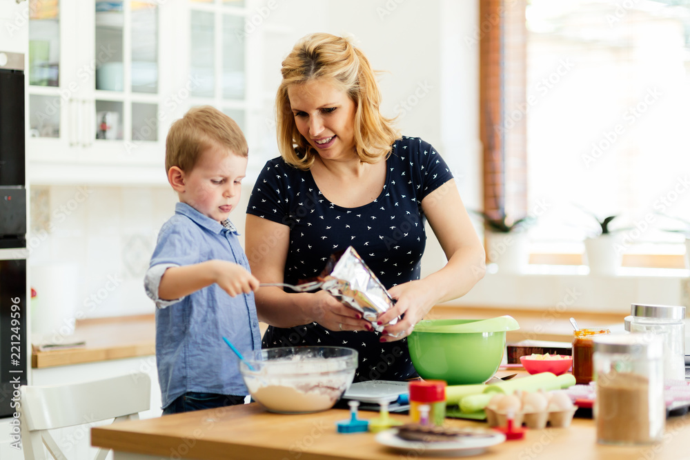 Smart cute child helping mother in kitchen