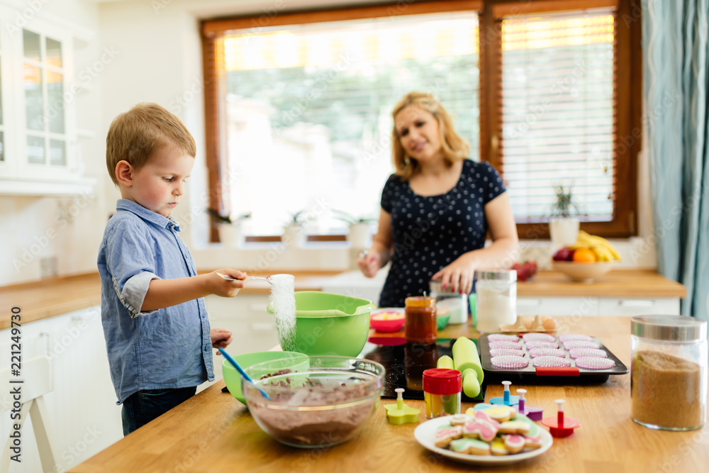 Child helping mother make muffins