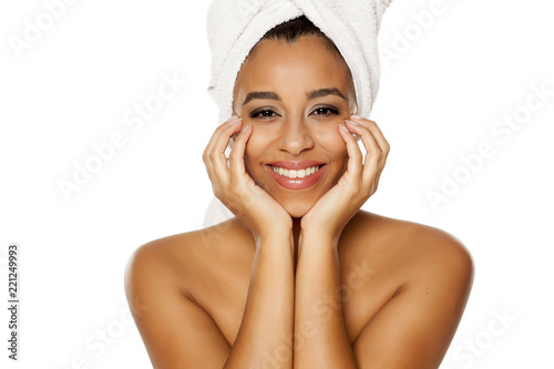 portrait of young beautiful dark-skinned woman with towel on her head, posing on a white background